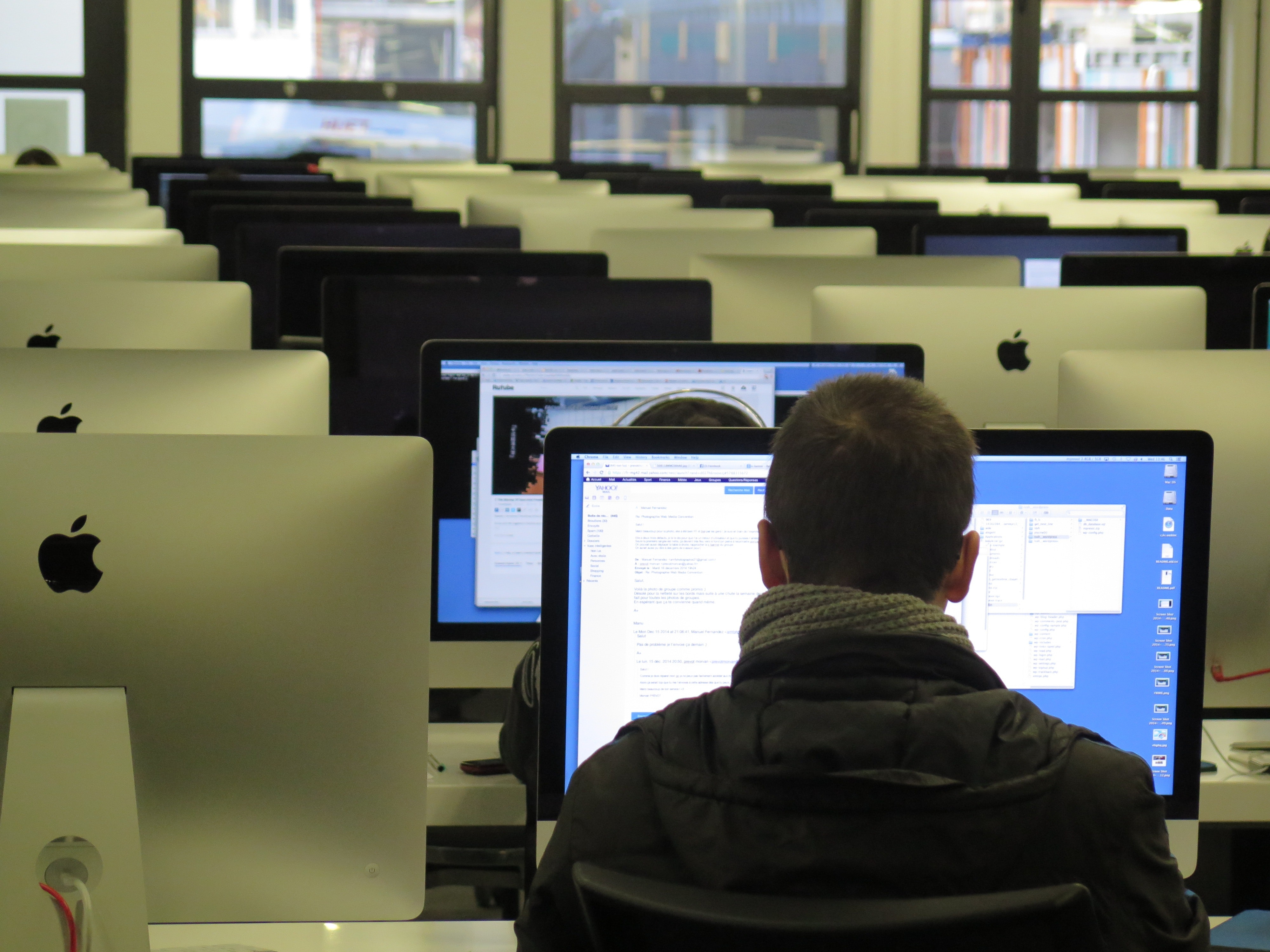"61% agree" - Man working at computer station in Library seated from behind